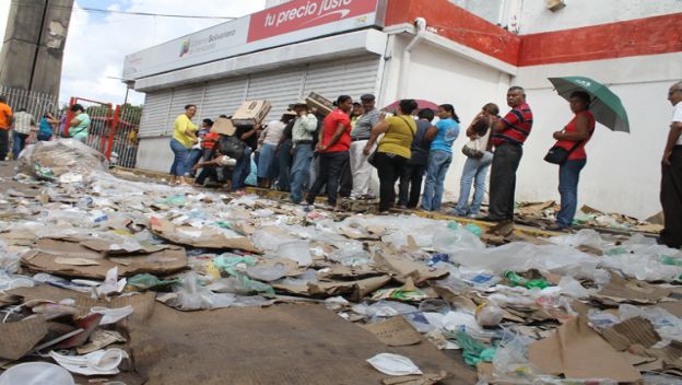 Entre basura y desperdicios hacen cola para comprar comida en Monagas