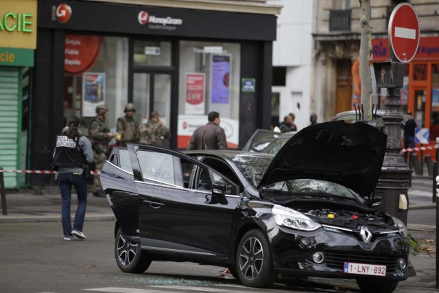 Police officers man a cordon around a car in the 18th district of Paris on November 17, 2015 which is suspected to have been involved in the November 13, 2015 terror attacks in which at least 129 people were killed.   AFP PHOTO / KENZO TRIBOUILLARD