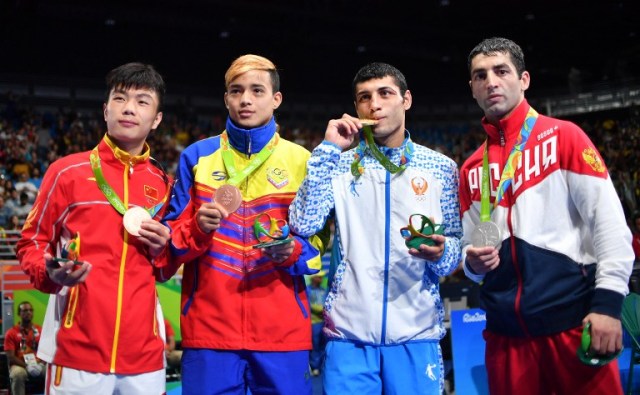 Gold medalist Uzbekistan's Shakhobidin Zoirov (2R), silver medalist Russia's Misha Aloian (R), and bronze medalists China's Hu Jianguan (L) and Venezuela's Yoel Segundo Finol react during the medal presentation ceremony following the Men's Fly (52kg) Final Bout at the Rio 2016 Olympic Games at the Riocentro - Pavilion 6 in Rio de Janeiro on August 21, 2016. / AFP PHOTO / Yuri CORTEZ