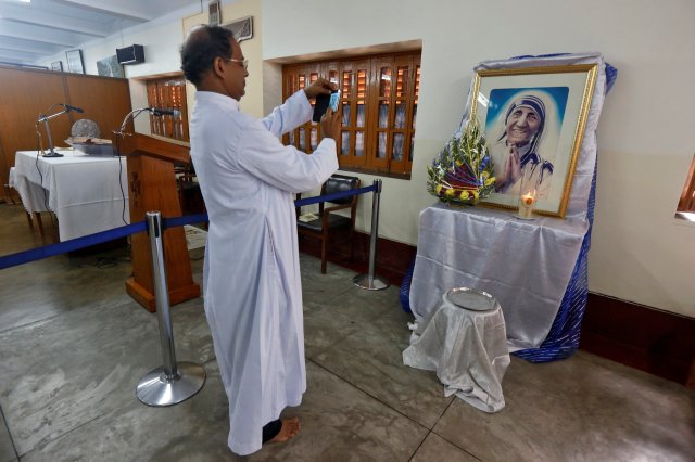 A man takes a photograph of a religious icon of Mother Teresa ahead of her canonisation ceremony, in Kolkata, India September 3, 2016. REUTERS/Rupak De Chowdhuri