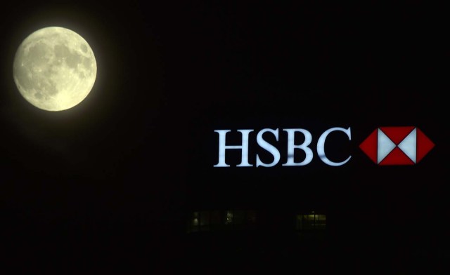 The moon rises over the HSBC building in the Canary Wharf financial district of London, a day before the "supermoon" spectacle, in London, Britain November 13, 2016. REUTERS/Hannah McKay