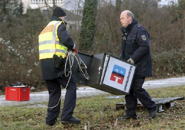 Agentes de la policía reúnen los restos de un cajero automático en la estación de tren  deDinslaken, Alemania, el 12 de enero de 2017. Parte de un tren de mercancías descarriló en Alemania tras golpear un cajero automático robado que había sido abandonado en una vía. (Roland Weihrauch/dpa via AP)