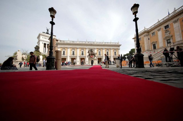 Workers lay a red carpet in front of the city hall "Campidoglio" (the Capitoline hill) as preparation for the meeting of EU leaders on the 60th anniversary of the Treaty of Rome, in Rome, Italy March 24, 2017. REUTERS/Alessandro Bianchi
