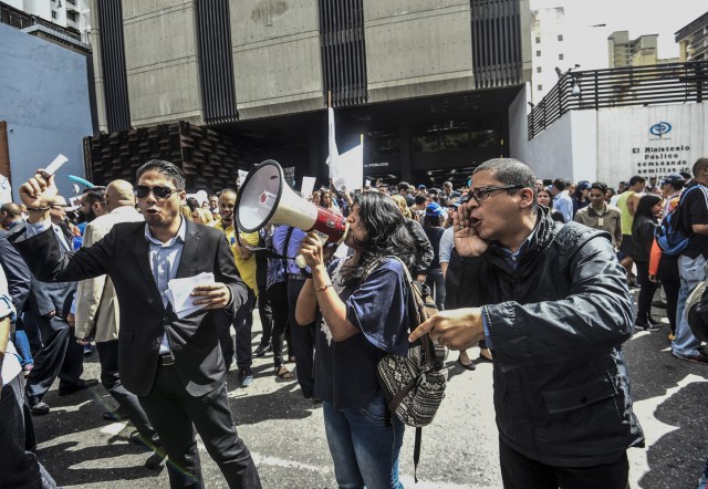 Venezuelan political scientist Necmar Evans (R) joins General Prosecutor's office employees demonstrating in support of Attorney General Luisa Ortega in Caracas on June 19 , 2017.   Venezuela's Supreme Court on Friday rejected a bid to put on trial several senior judges accused of favoring embattled President Nicolas Maduro as he clings to power in the face of deadly unrest. / AFP PHOTO / JUAN BARRETO