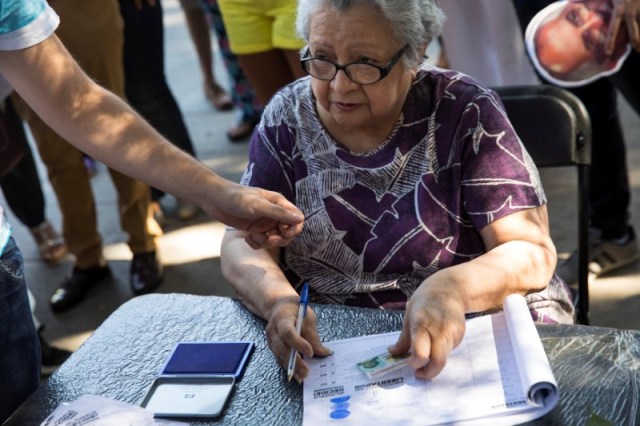 Una mujer se prepara para votar durante un plebiscito no oficial contra el presidente de Venezuela, Nicolás Maduro, en Madrid, España, el 16 de julio de 2017. REUTERS/Juan Medina