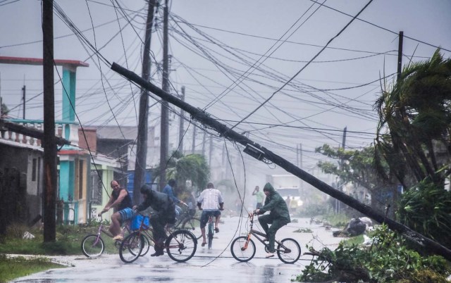 Local residents return home after the passage of Hurricane Irma in Caibarien, Villa Clara province, 330km east of Havana, on September 9, 2017. Irma's blast through the Cuban coastline weakened the storm to a Category Three, but it is still packing 125 mile-an-hour winds (205 kilometer per hour) and was expected to regain power before hitting the Florida Keys early Sunday, US forecasters said. The Cuban government extended its maximum state of alert to three additional provinces, including Havana, amid fears of flooding in low-lying areas. / AFP PHOTO / ADALBERTO ROQUE