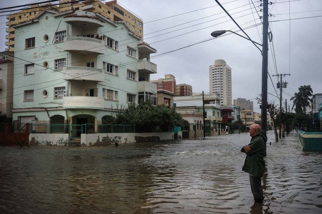 A man stands in a flooded street during the passage of Hurricane Irma in Havana, on September 9, 2017. Irma's blast through the Cuban coastline weakened it to a Category Three, but it is still packing winds of 125 miles (200 kilometer) per hour. / AFP PHOTO / YAMIL LAGE