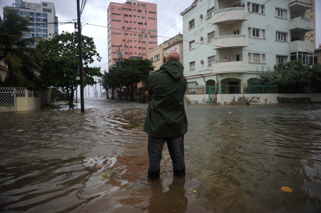 A man stands in a flooded street during the passage of Hurricane Irma in Havana, on September 9, 2017. Irma's blast through the Cuban coastline weakened it to a Category Three, but it is still packing winds of 125 miles (200 kilometer) per hour. / AFP PHOTO / YAMIL LAGE