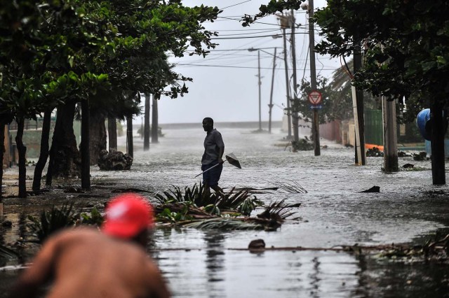 A man walks in a flooded street during the passage of Hurricane Irma in Havana, on September 9, 2017. Irma's blast through the Cuban coastline weakened it to a Category Three, but it is still packing winds of 125 miles (200 kilometer) per hour. / AFP PHOTO / YAMIL LAGE