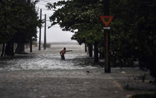 A man wades through a flooded street during the passage of Hurricane Irma, in Havana, on September 9, 2017. Irma's blast through the Cuban coastline weakened it to a Category Three, but it is still packing winds of 125 miles (200 kilometer) per hour. / AFP PHOTO / YAMIL LAGE