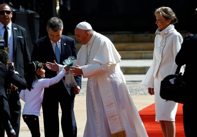 Colombia's President Juan Manuel Santos (L) and First Lady Maria Clemencia Rodriguez (R) look on as a girl greets Pope Francis during a meeting at Narino presidential palace in Bogota, Colombia September 7, 2017. REUTERS/Stefano Rellandini