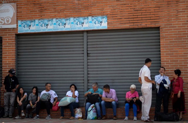 People wait to board a bus at a bus in Caracas on October 11, 2017 as scores of disappointed Venezuelans who see no end to the crisis choose to leave the country. Venezuela, which holds regional elections on October 15, is a country at the top of the Latin American continent that is in deep economic and political crisis. / AFP PHOTO / Federico PARRA
