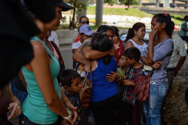 People bid farewell to relatives before boarding a bus at a station in Caracas on October 11, 2017 as scores of disappointed Venezuelans who see no end to the crisis choose to leave the country. Venezuela, which holds regional elections on October 15, is a country at the top of the Latin American continent that is in deep economic and political crisis. / AFP PHOTO / Federico PARRA