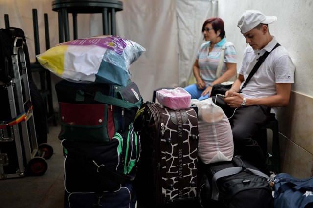 People queue to buy tickets to travel to Ecuador at a bus station in Caracas, on October 11, 2017 as scores of disappointed Venezuelans who see no end to the crisis choose to leave the country. Venezuela, which holds regional elections on October 15, is a country at the top of the Latin American continent that is in deep economic and political crisis. / AFP PHOTO / Federico PARRA