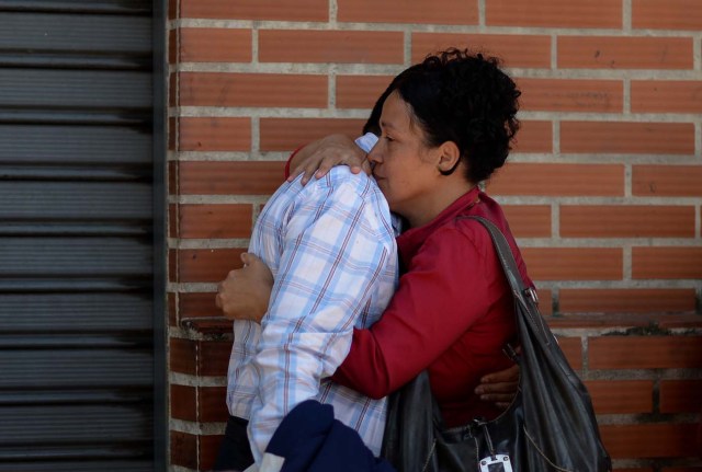 A couple embraces before boarding a bus at a station in Caracas on October 11, 2017 as scores of disappointed Venezuelans who see no end to the crisis choose to leave the country. Venezuela, which holds regional elections on October 15, is a country at the top of the Latin American continent that is in deep economic and political crisis. / AFP PHOTO / Federico PARRA