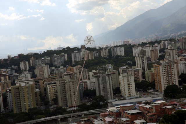  Una cometa sobrevuela casas en el barrio de Petare en Caracas, Venezuela, 29 de agosto de 2017. Foto tomada el 29 de agosto de 2017. Para coincidir con la característica VENEZUELA-NIÑOS / REUTERS / Andres Martínez Casares