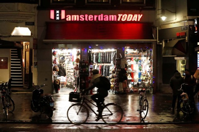 A cyclist rides past a touristic shop in Amsterdam, Netherlands, December 1, 2017. REUTERS/Yves Herman