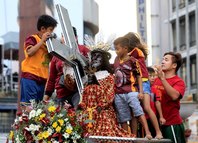 Devotees are seen atop of the the carriage of the Black Nazarene replica during an annual procession in Quiapo city, Metro Manila, Philippines January 7, 2018. REUTERS/Romeo Ranoco