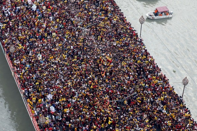 Devotees flock as a carriage bearing an image of Black Nazarene makes its way through the Jones bridge during the annual religious procession in Manila, Philippines January 9, 2018. REUTERS/Erik De Castro