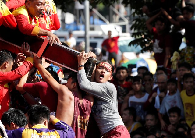 Devotees cling on the cross of an image of Black Nazarene during the annual religious procession in Manila, Philippines, January 9, 2018. REUTERS/Erik De Castro