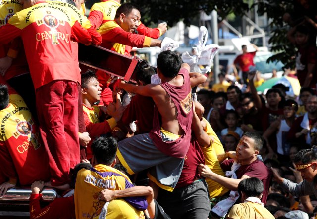 Devotees cling on the cross of an image of Black Nazarene during the annual religious procession in Manila, Philippines, January 9, 2018. REUTERS/Erik De Castro