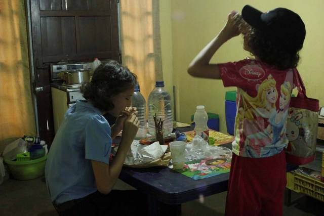 Magdalena (L) y Barbara, hijas de Isabel Colina, comen en su casa en Socopo, Venezuela el 1 de marzo de 2018. Foto tomada el 1 de marzo de 2018. REUTERS / Carlos Eduardo Ramirez