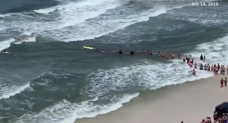 Hicieron una cadena humana para salvar a dos nadadores de morir ahogados en pleno huracán (Video)